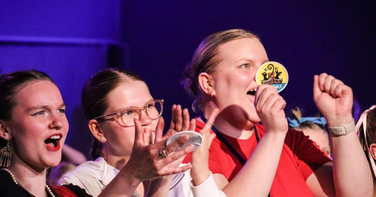 Kolme nuorta osoittaa suosiota Kalena kangasmerkit käsissään.